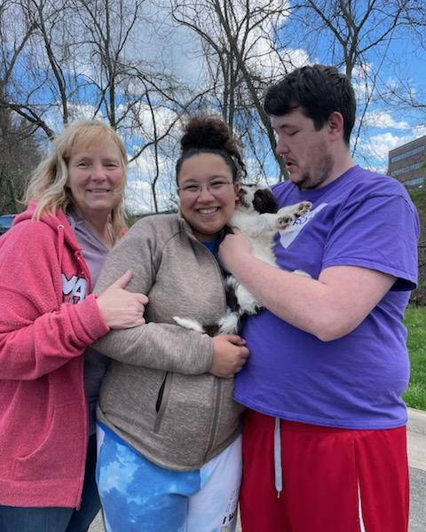 Family of 3 holding their newly adopted puppy in their arms